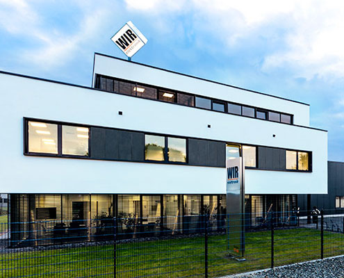 WIR_elektronik_Gebäude_Verwaltungstrakt_Wolken_rahmend_Banner_495x400
